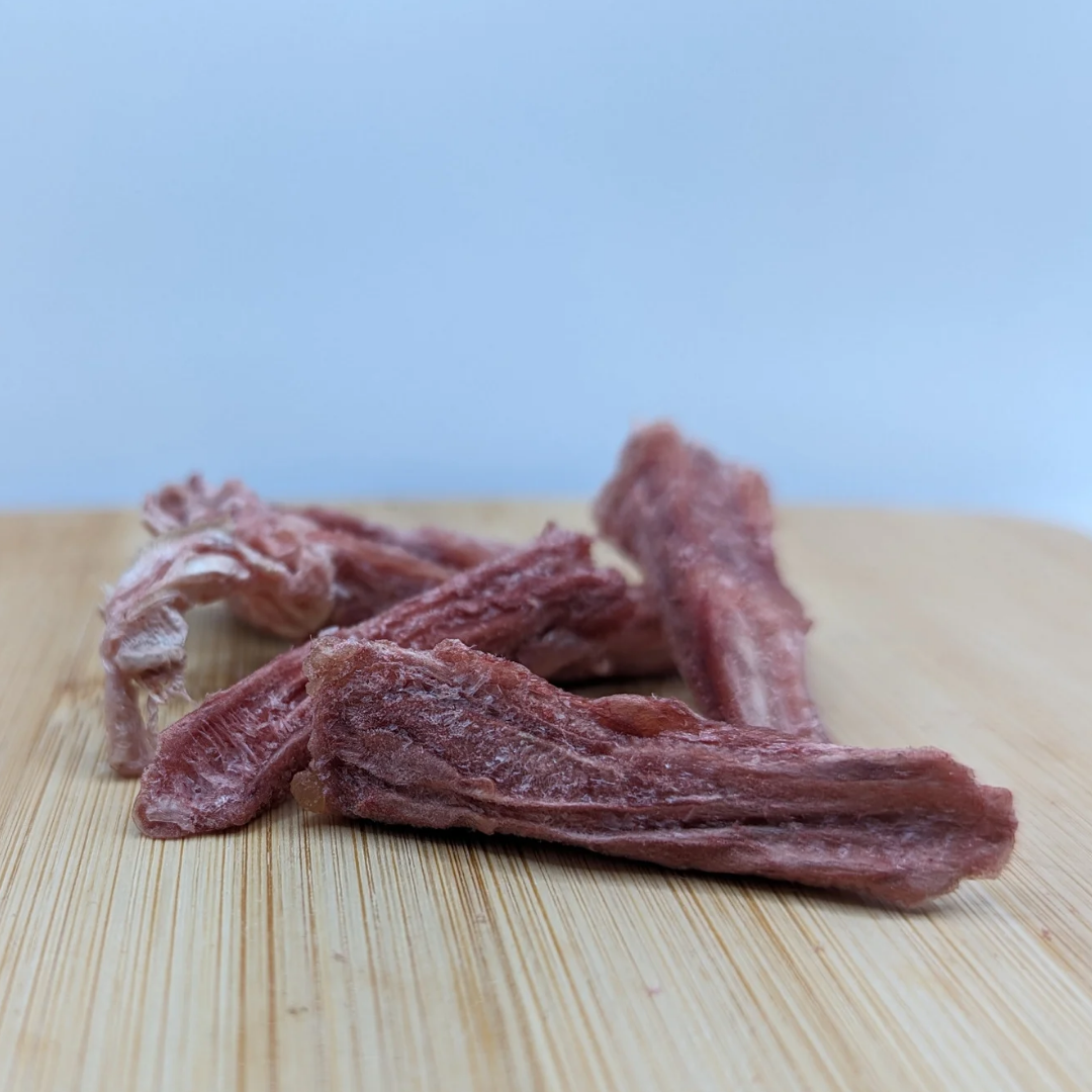Freeze-dried Duck Tongues 1oz from Beast Feast on a wooden cutting board.