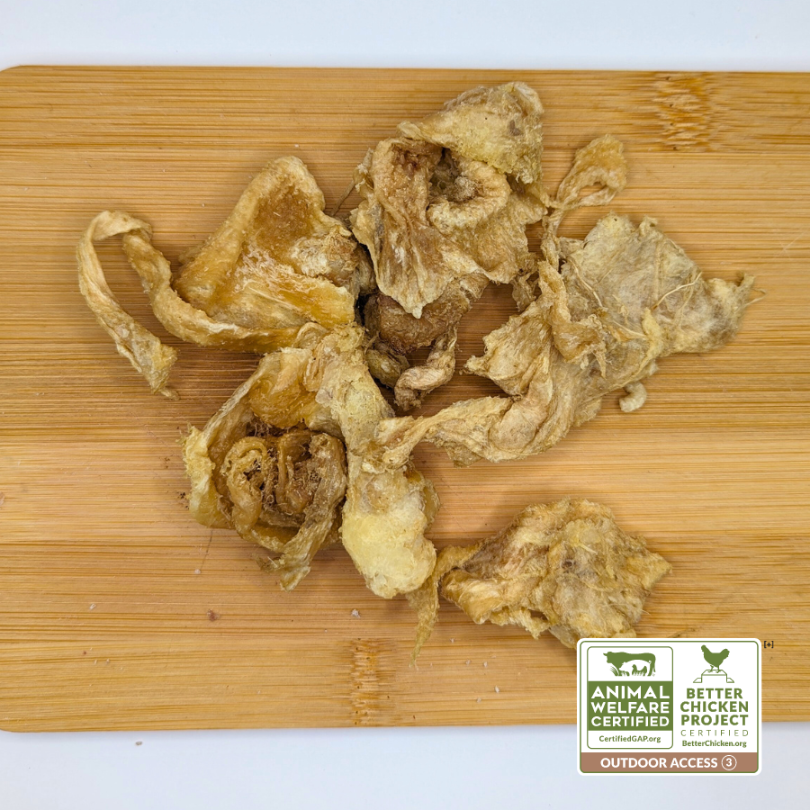 Pieces of dried mushrooms on a wooden cutting board. The lower right corner displays certifications for Animal Welfare and Better Chicken Project, highlighted by the "Outdoor Access 3" label. Ideal for creating healthy treats like Beast Feast Freeze-Dried Chicken Collagen Chomps 3oz, beneficial for senior dogs dealing with arthritis.