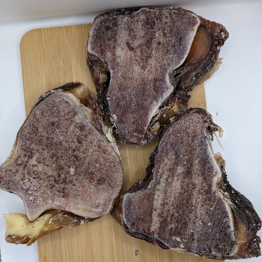 Three Beast Feast bison knuckle slices on a cutting board for older dogs with sensitive teeth.