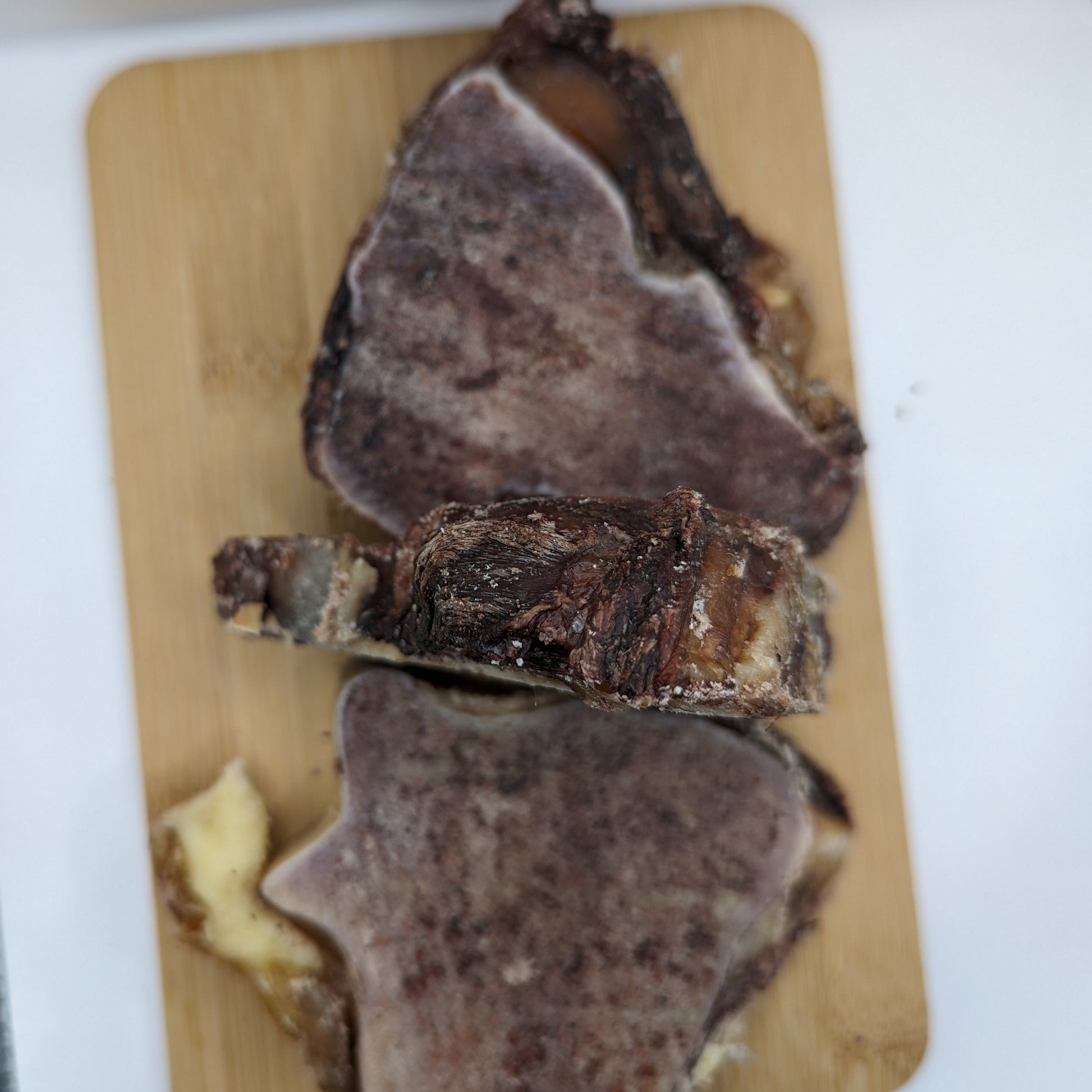 A piece of Bison Knuckle Slices on the cutting board, perfect for older dogs with sensitive teeth from Beast Feast.