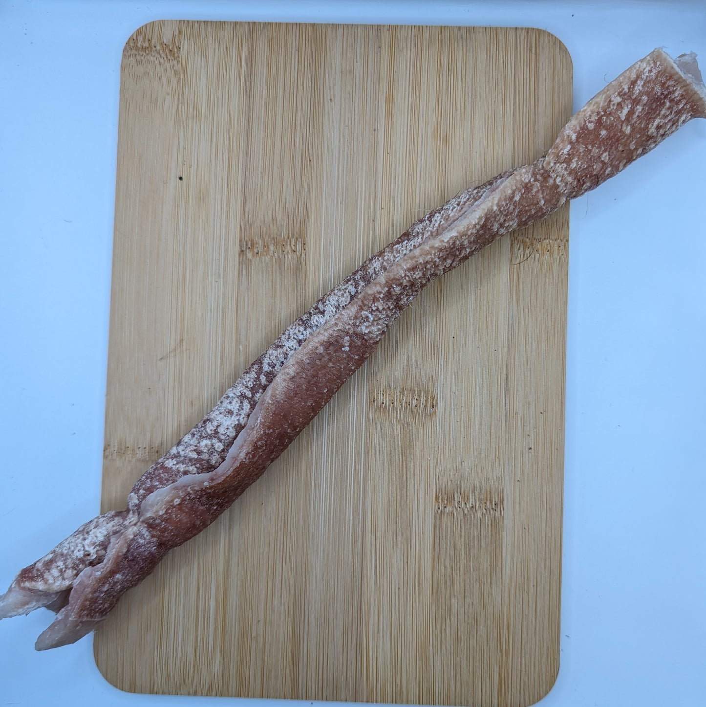 A Beast Feast heritage breed freeze-dried pork roll sits on a cutting board.