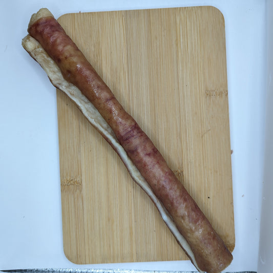 A long piece of Heritage Breed Dehydrated Pork Rolls from Beast Feast on a cutting board.