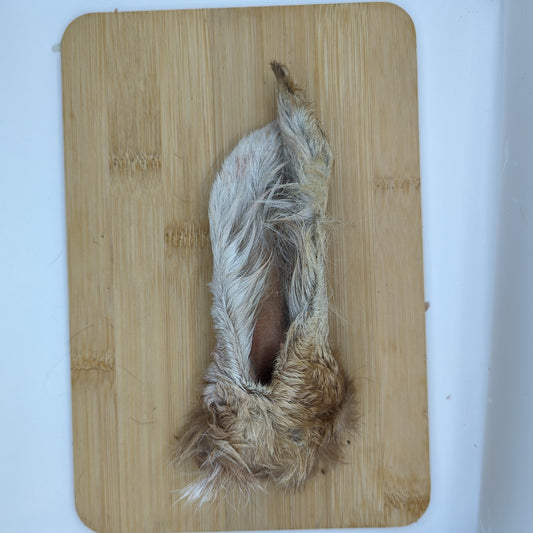 A low-fat chew made from natural fiber, such as Hairy Goat Ears, on a cutting board by Beast Feast.