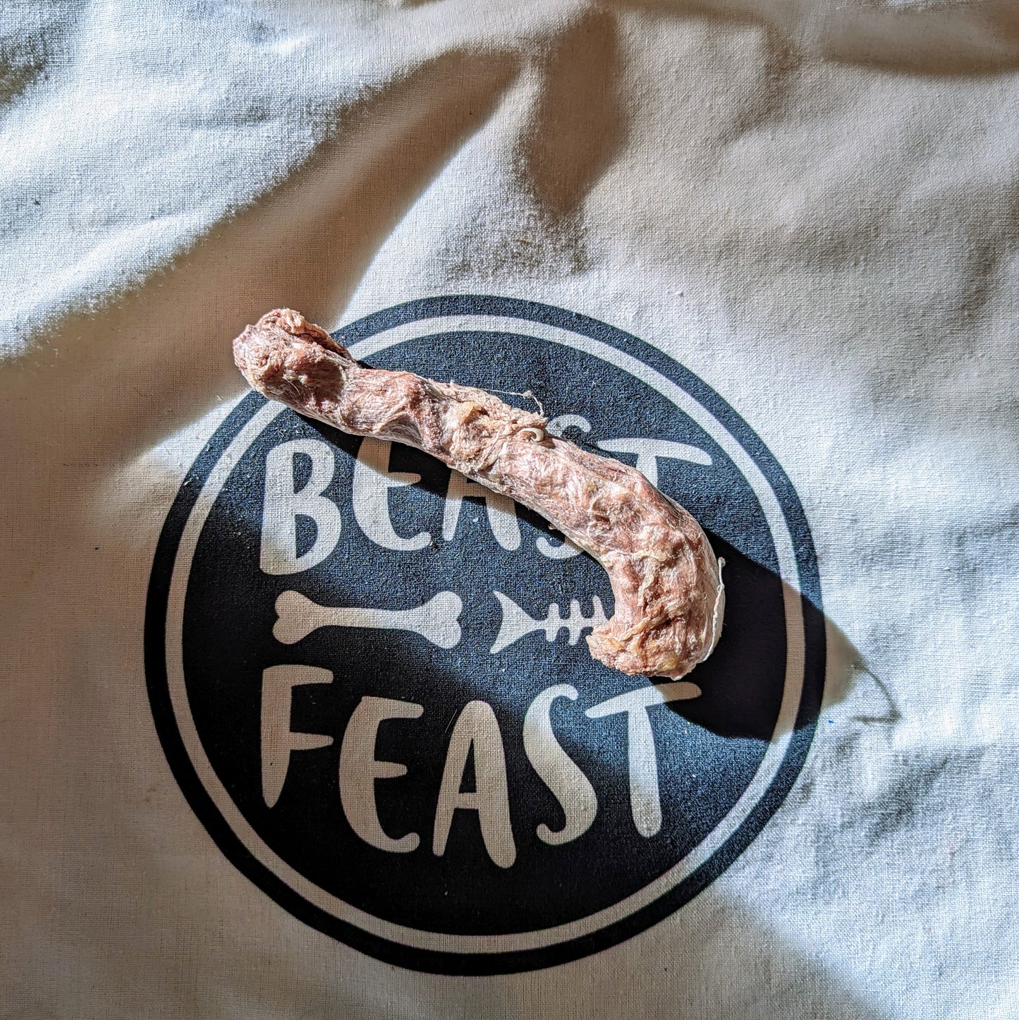 A piece of Freeze-Dried Pheasant Neck on a bag with the word Beast Feast on it, promoting clean teeth and joint health.