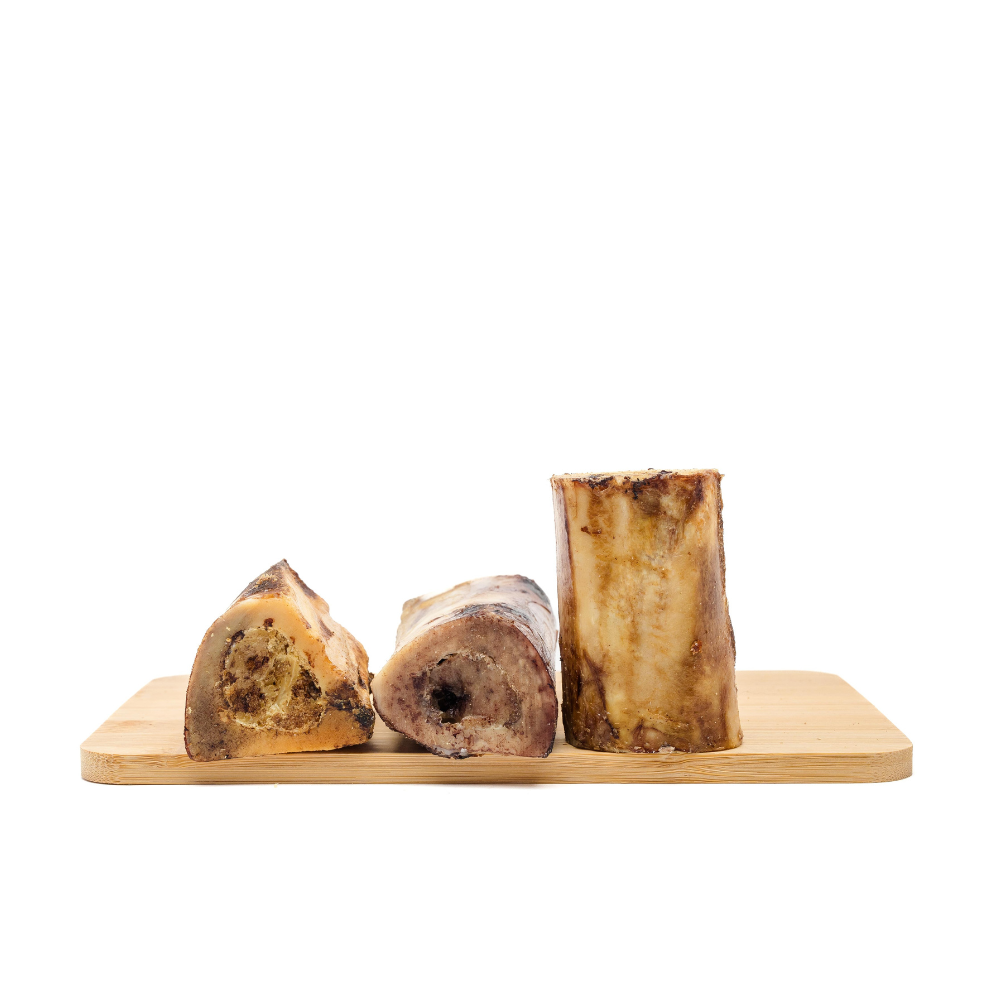 Three Beast Feast Smoked Bison Marrow Bones on a wooden cutting board.