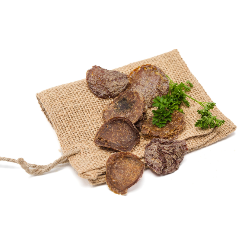 A bag full of Beast Feast Bison Crispers and herbs on a white background.