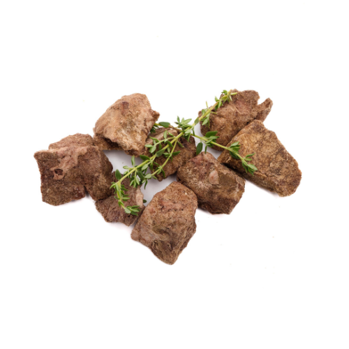 Pieces of Freeze-Dried Bison Organ Medley with a sprig of thyme on a white background, freeze-dry for a healthy treat.