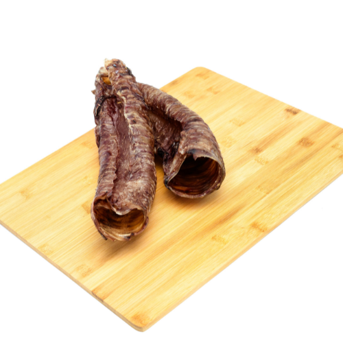 Crispy Beast Feast Bison Tracheas, an excellent source of glucosamine and chondroitin, laid on a rustic wooden cutting board.